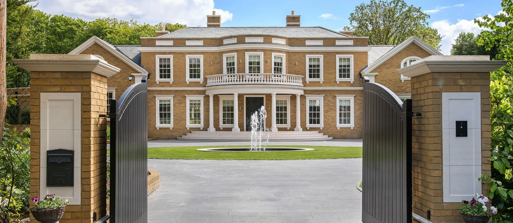 Gates opening up to a large private luxury mansion